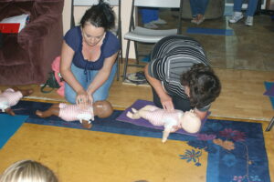 Cpr class practicing infant chest compressions.
