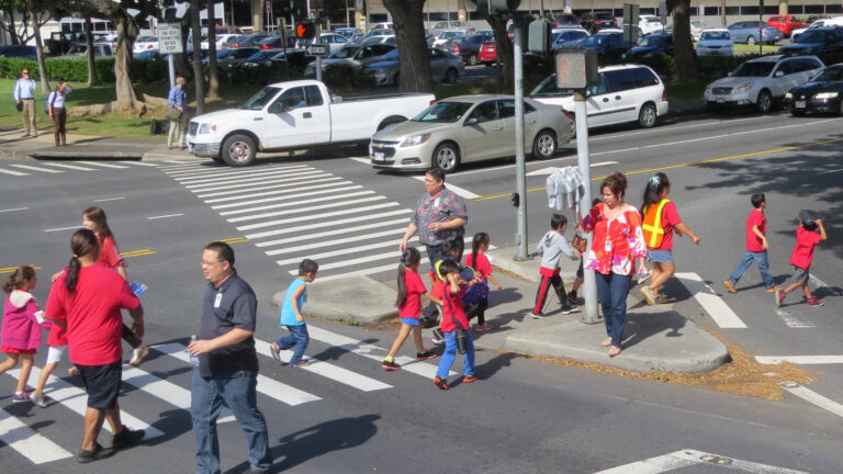 Children on field trip crossing the street with teachers.